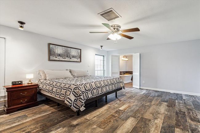 A huge primary bedroom offers the luxury of space, allowing for the creation of a cozy sitting area where you can unwind and relax. The beautiful tile flooring adds to its appeal, providing a modern look while also offering practical benefits such as durability and easy maintenance | Image 10