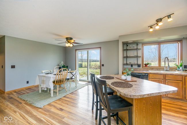 kitchen featuring light countertops, a sink, a kitchen island, light wood finished floors, and dishwasher | Image 6