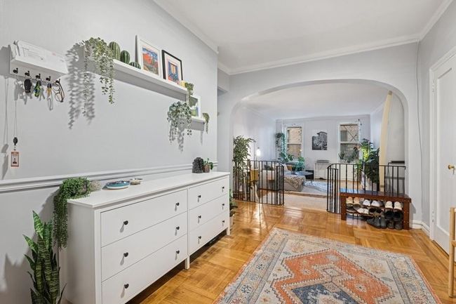 Hallway with arched walkways, baseboards, and ornamental molding | Image 9