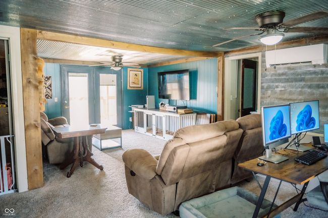 carpeted living area featuring a wall mounted air conditioner and a ceiling fan | Image 32