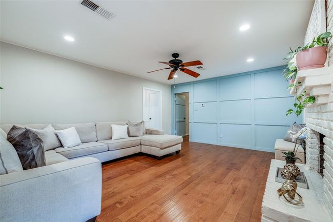 Beautiful family room with gorgeous wood floors, recessed lighting, ceiling fan, floor to ceiling brick fireplace with gas burning log fire | Image 11