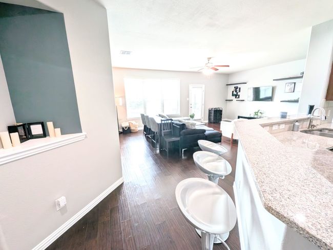 Living area featuring a ceiling fan and dark wood finished floors | Image 9