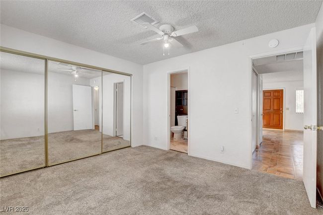 Unfurnished bedroom with a closet, ensuite bath, a textured ceiling, carpet floors, and visible vents | Image 22