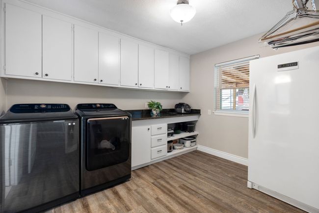 Laundry with granite countertops and plenty of storage cabinets. Room for freezer and hanging clothes rack. | Image 32
