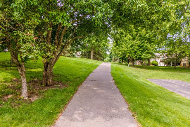 This property backs onto a tranquil paved path and wide open lawn—ideal for casual walks or neighborhood activities just outside your door. | Image 31