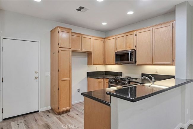 KITCHEN WITH STAINLESS APPLIANCES, BREAKFAST BAR AND PANTRY | Image 14