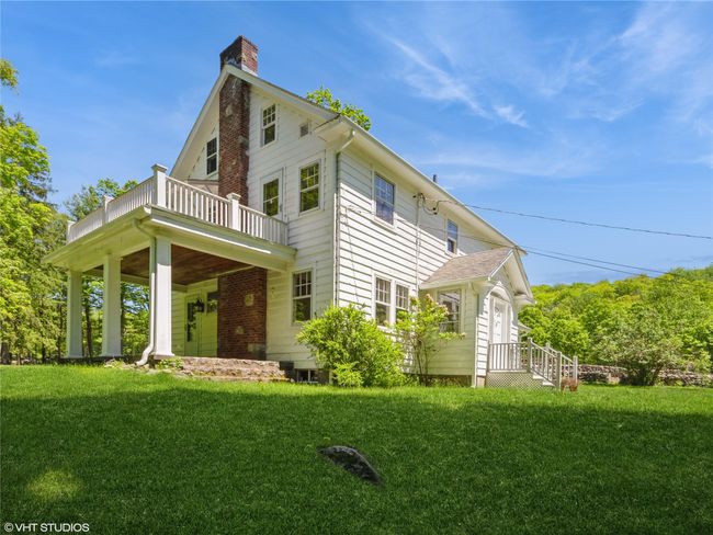 View of property exterior featuring a yard, a chimney, and a balcony | Image 11