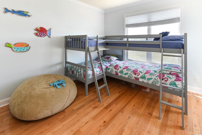 Bedroom with crown molding, baseboards, and wood finished floors | Image 17
