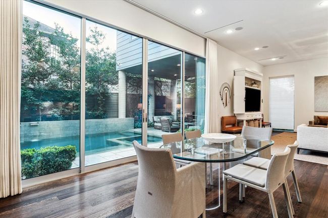 Expansive near floor to ceiling windows and sliding glass doors allow for an abundance of natural light to enter the interior spaces and provide easy access to the outdoor pool areas. | Image 15