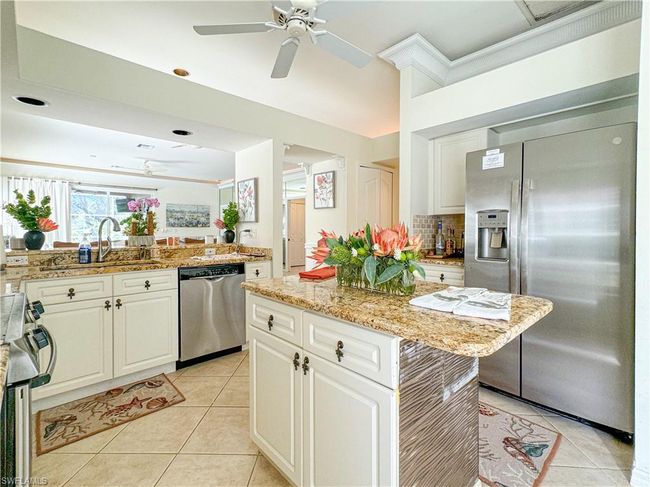 Kitchen featuring a kitchen island, stainless steel appliances, tasteful backsplash, ceiling fan, and light tile floors | Image 40