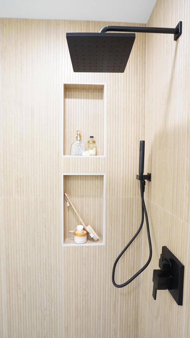 Flanked by the high end shower trim pieces, this custom, easily accessible double niche has ample room for toiletries of all shapes and sizes. | Image 16
