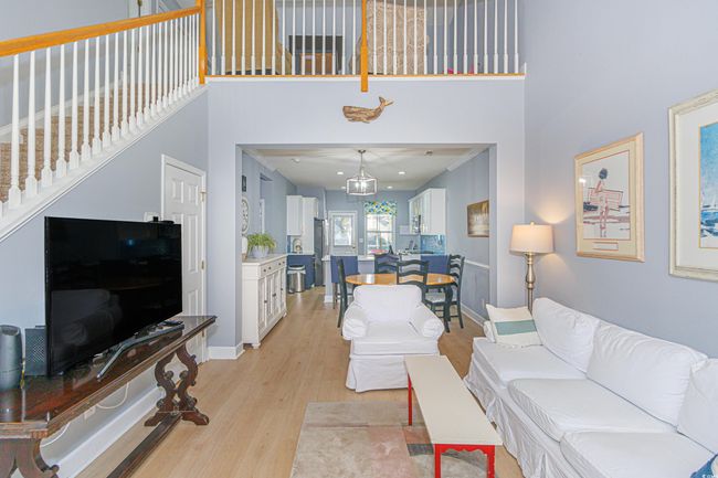 Living room featuring a towering ceiling and light hardwood / wood-style floors | Image 5