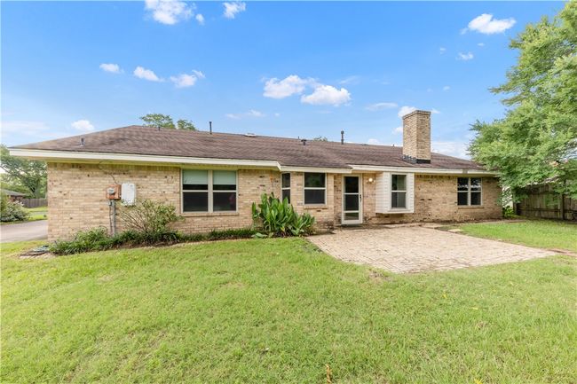 Rear view of house featuring a chimney, a patio, and brick siding | Image 19
