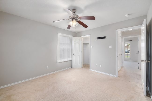 bedroom featuring baseboards, ceiling fan, a spacious closet, and light colored carpet | Image 18