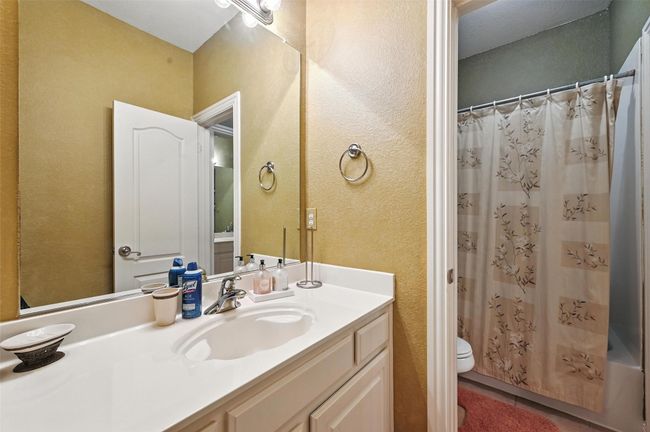 Full bathroom featuring a textured wall, vanity, and shower / bath combo | Image 20
