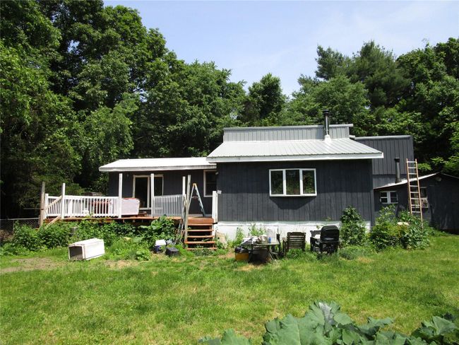 View of front facade featuring metal roof and a wooden deck | Image 5
