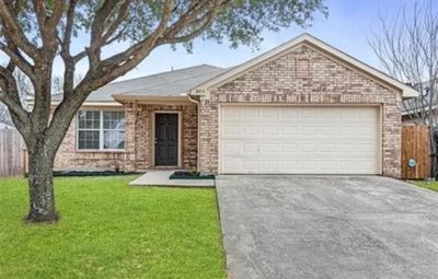 Single story home featuring a front lawn and a garage | Image 1