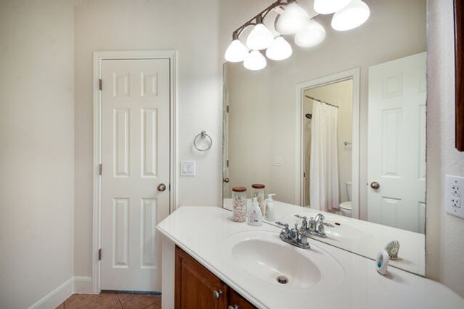 Full bathroom featuring vanity, toilet, tile patterned floors, baseboards, and a chandelier | Image 16