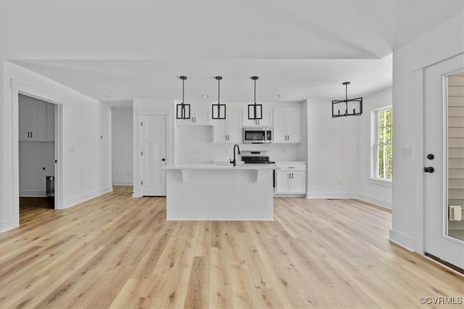Kitchen featuring white cabinetry, baseboards, light countertops, and appliances with stainless steel finishes | Image 10
