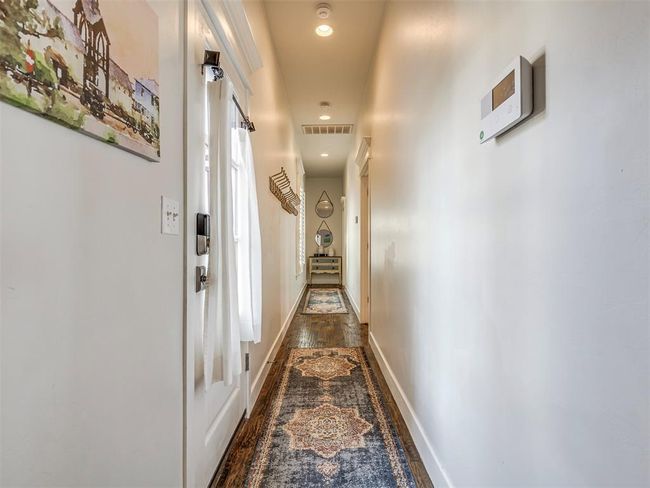 Hall featuring dark wood-style flooring, recessed lighting, visible vents, and baseboards | Image 13