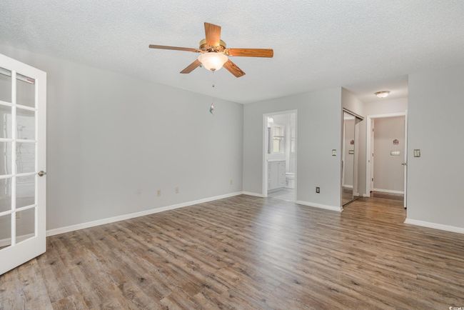 Spare room featuring ceiling fan, baseboards, wood finished floors, and a textured ceiling | Image 17