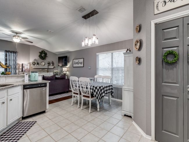 Kitchen featuring dishwasher, lofted ceiling, white cabinets, light tile patterned floors, and ceiling fan | Image 14