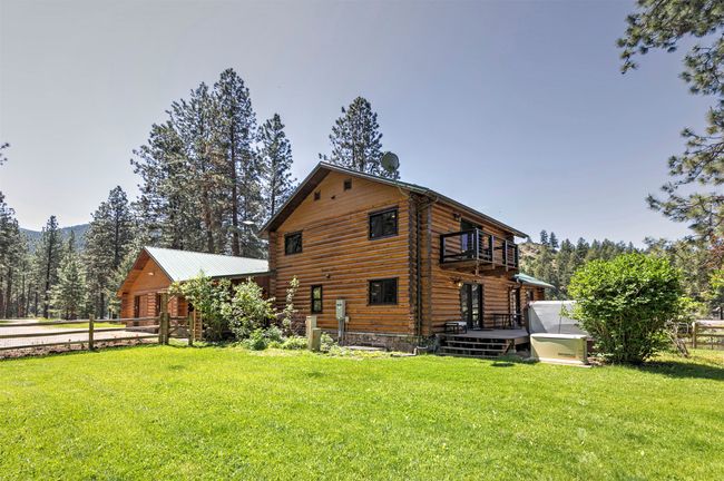 Rear view of house with a deck, a balcony, log exterior, and an attached garage | Image 55