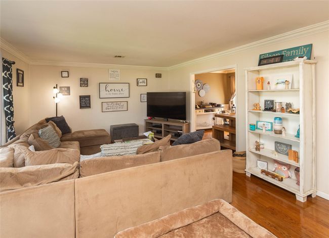 Living room with ornamental molding and wood finished floors | Image 5