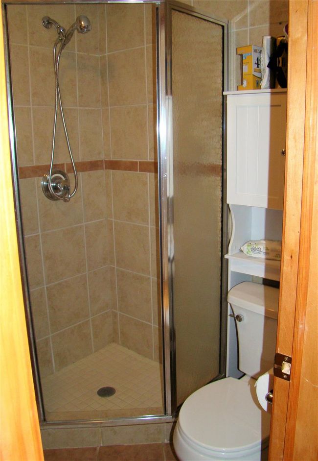 Bathroom featuring toilet and a shower with shower door | Image 22
