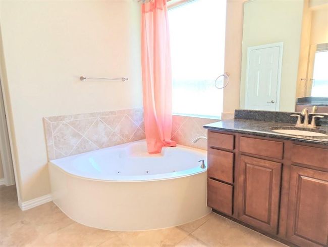 Bathroom featuring a whirlpool tub, vanity, and tile patterned floors | Image 20