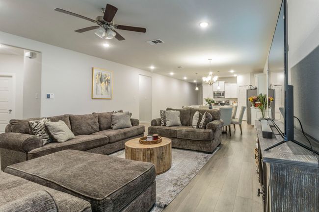 Living room with a ceiling fan, a chandelier, light wood-type flooring, and recessed lighting | Image 5