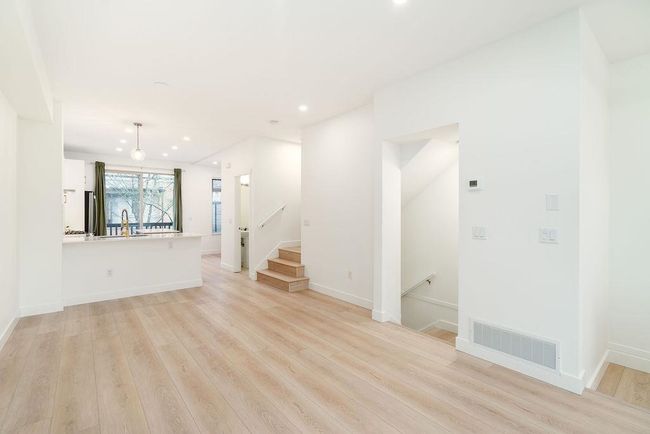 Unfurnished living room featuring recessed lighting, baseboards, a sink, light wood finished floors, and visible vents | Image 17