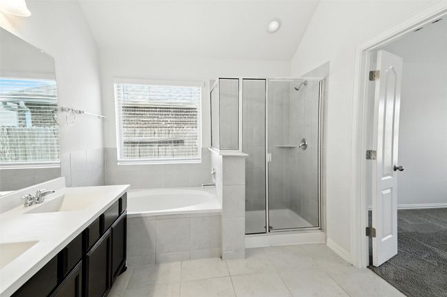 Full bath with vaulted ceiling, a garden tub, double vanity, a stall shower, and tile patterned floors | Image 31