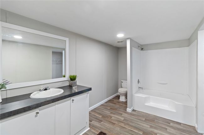 Full bath featuring wood finished floors, vanity, shower / washtub combination, baseboards, and toilet | Image 23
