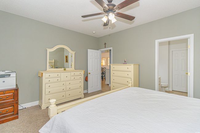 Bedroom with ensuite bathroom, light colored carpet, and ceiling fan | Image 16