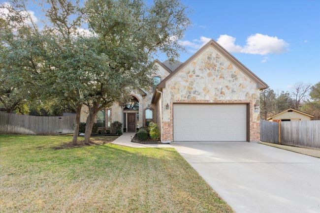 View of front of property with a garage, concrete driveway, a front lawn, and fence | Image 5