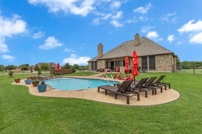 View of pool featuring a patio area and a pool with connected hot tub | Image 35