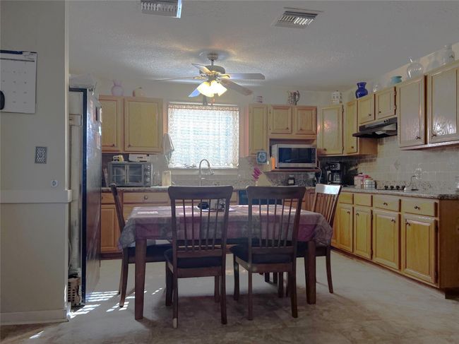 View of dining area and kitchen from the living room. | Image 19