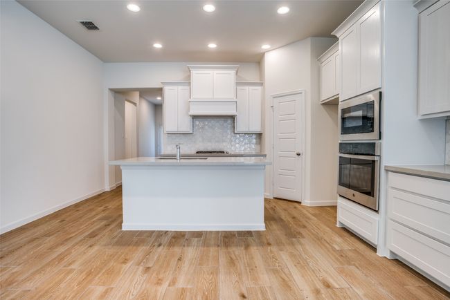 Kitchen with oven, built in microwave, tasteful backsplash, light countertops, and light wood finished floors | Image 9