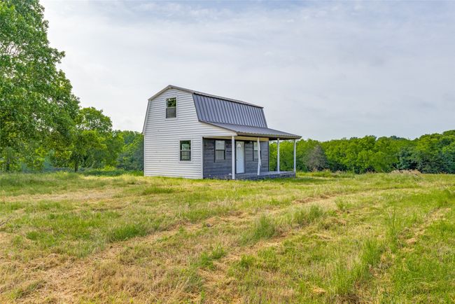 Rear view of house featuring a gambrel roof and a metal roof | Image 29