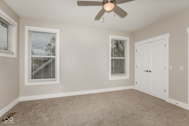 unfurnished bedroom with baseboards, carpet floors, ceiling fan, and a closet | Image 5