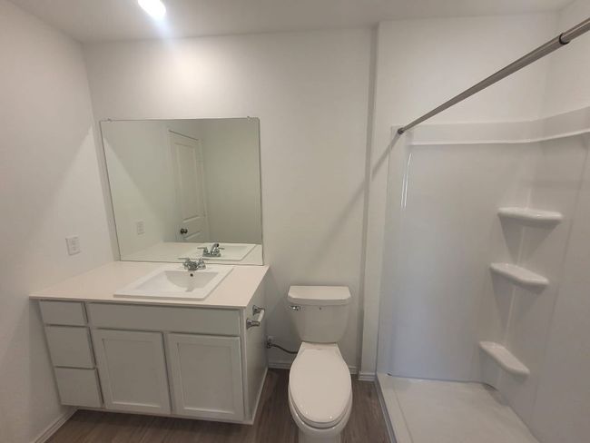 Bathroom featuring a shower, wood vinyl finished floors, and vanity | Image 11