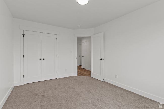 Unfurnished bedroom with carpet floors, baseboards, and a closet | Image 14