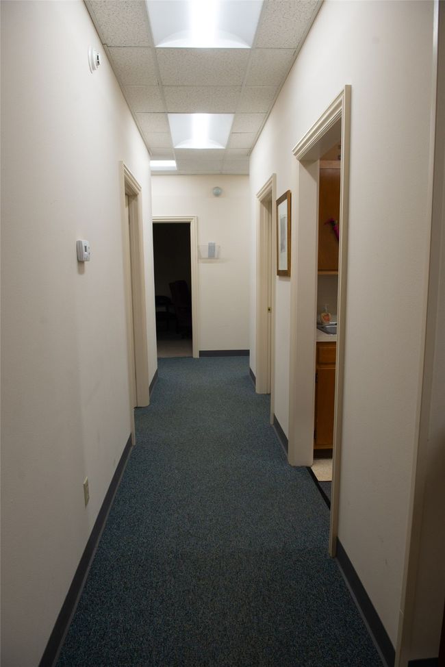 Corridor with baseboards, a paneled ceiling, and carpet | Image 9