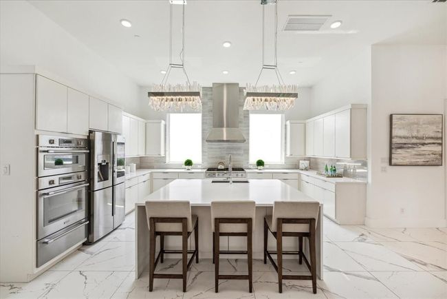 KITCHEN: This gourmet kitchen is a chef's dream, featuring sleek, high-end THERMADOR appliances seamlessly integrated into custom cabinetry. The minimalist aesthetic is enhanced by clean lines and a neutral color palette, creating a sophisticated and inviting atmosphere. | Image 14