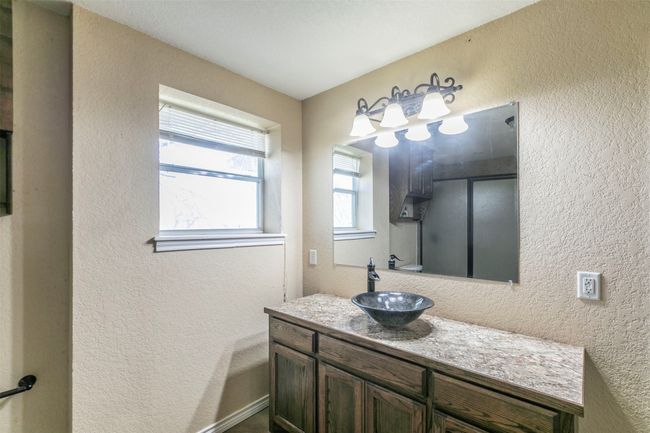 Bathroom with a textured wall and vanity | Image 17