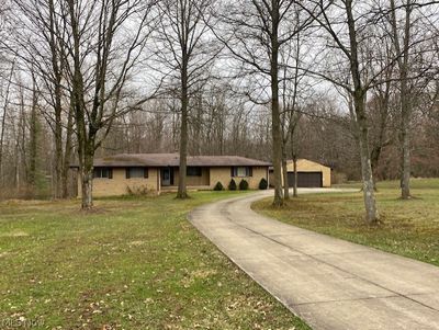 View of front of property featuring adetached 2-car garage and a front yard | Image 1