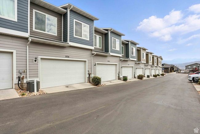 View of asphalt street and 2 car attached garage featuring a residential view | Image 44