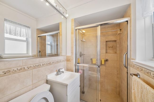 Bathroom featuring tile walls and stall shower | Image 9