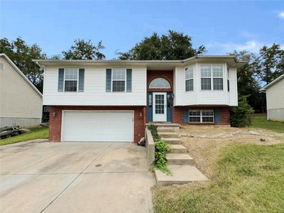 Split foyer home with a front yard and a garage | Image 1